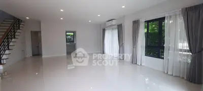 Spacious modern living room with large windows and elegant curtains