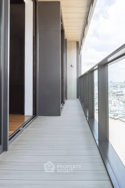 Modern high-rise balcony with city view and sleek railing design.
