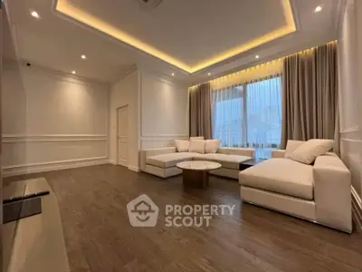 Luxurious modern living room with elegant lighting and plush white sofas.