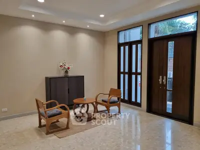 Elegant living room with modern furniture and large windows, perfect for natural light and relaxation.