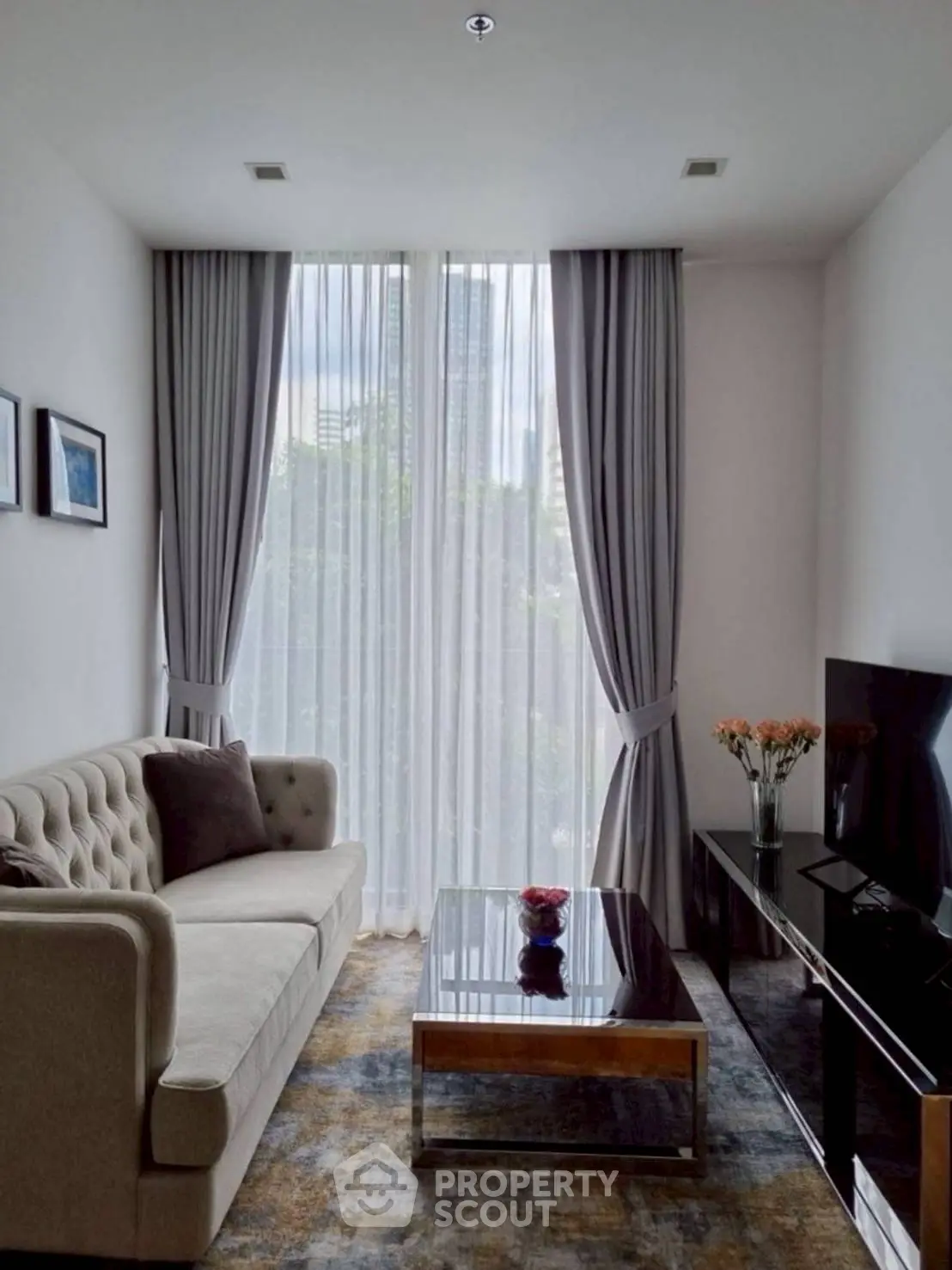 Elegant living room with plush sofa, large window, and modern decor in a stylish apartment.