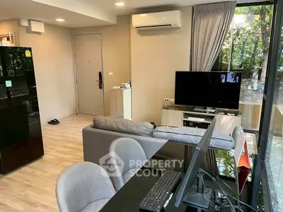 Modern living room with sleek furniture and large windows offering garden view