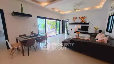 Spacious modern living room with elegant decor and large windows opening to a garden view.