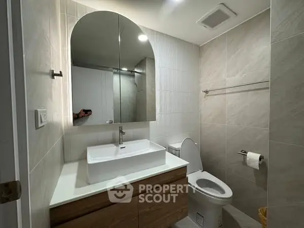 Modern bathroom with sleek vanity and large mirror in contemporary home.