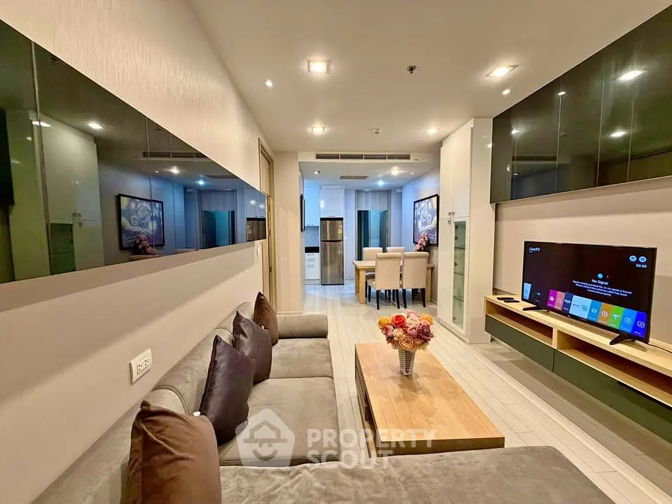 Modern living room with sleek design and open kitchen layout, featuring a cozy sofa and stylish decor.