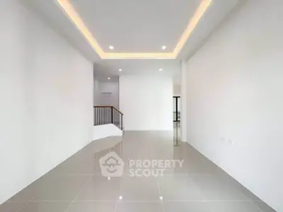 Spacious modern living room with sleek tile flooring and recessed lighting.