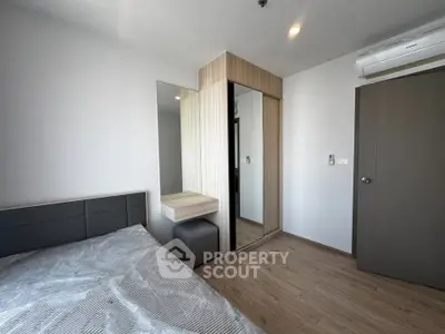 Modern bedroom with sleek design and mirrored wardrobe in a stylish apartment.