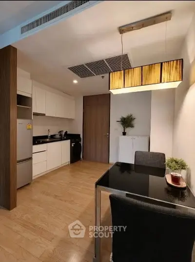Modern kitchen with sleek cabinetry and dining area in stylish apartment
