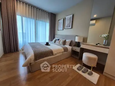 Elegant bedroom with cozy decor and natural light, featuring a stylish bed and wooden flooring.