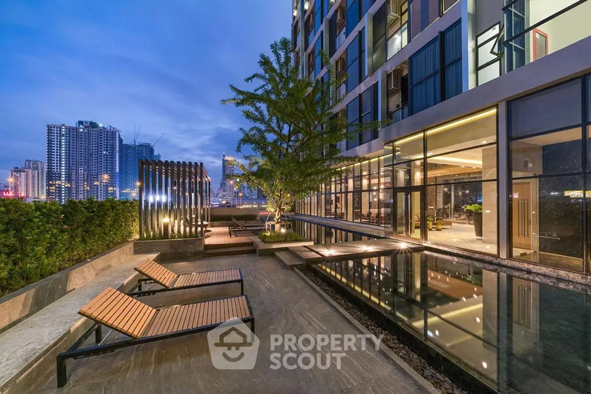 Luxurious modern apartment building with stunning poolside view and city skyline.