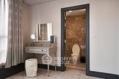 Elegant bedroom with ensuite bathroom featuring modern decor and stylish vanity area.