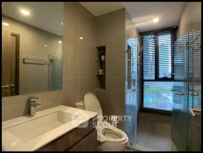 Modern bathroom with sleek fixtures and large window offering natural light.