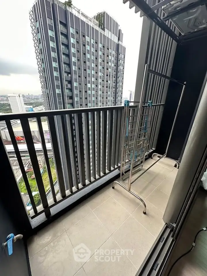 Modern high-rise balcony with city view and drying rack, perfect for urban living.