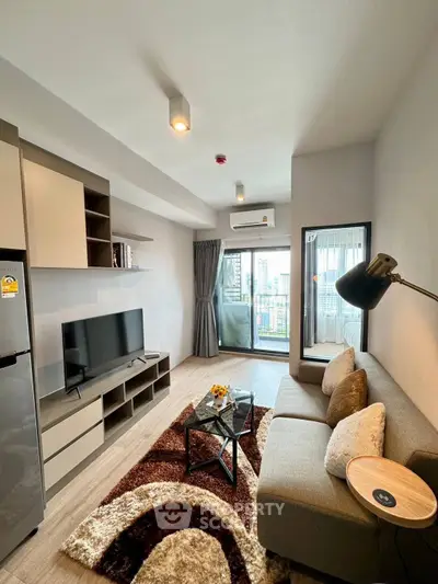 Modern living room with stylish decor and balcony view in a contemporary apartment.