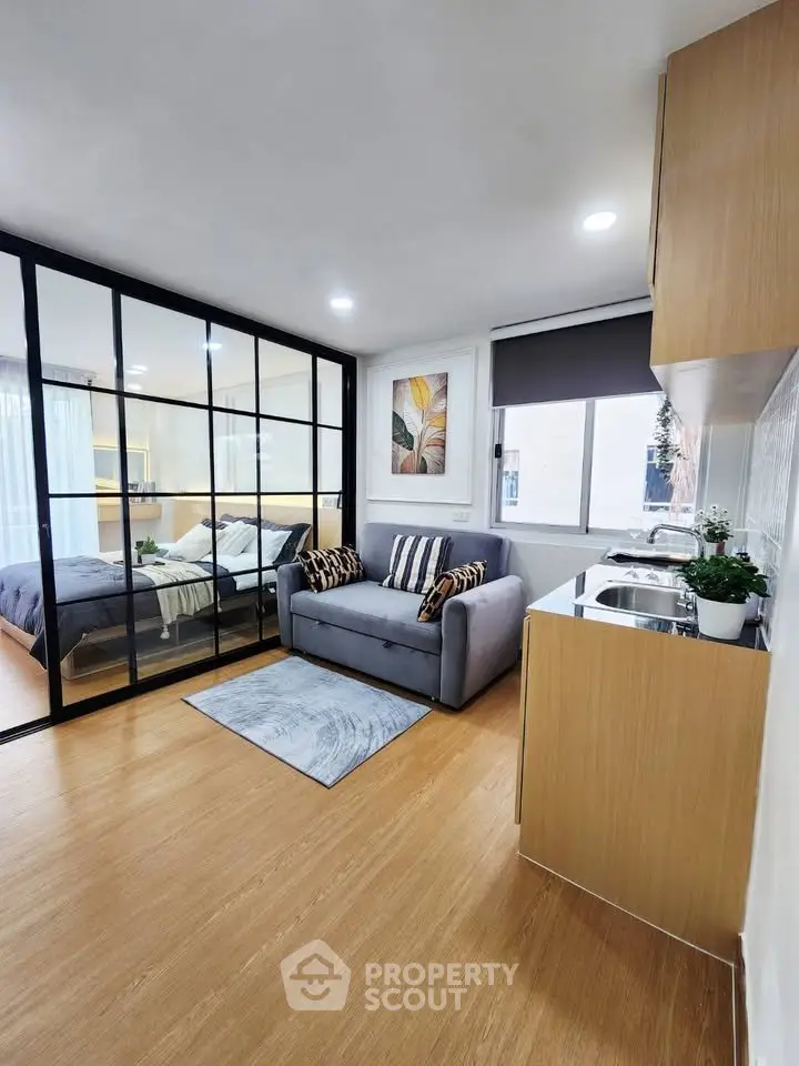 Modern studio apartment with open layout, featuring cozy living area and stylish kitchen.
