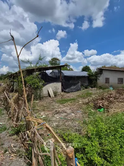 Rural property with rustic structures under a vibrant blue sky, ideal for agricultural development.