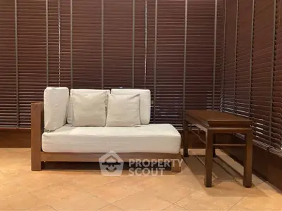 Stylish minimalist living room with wooden blinds and modern furniture