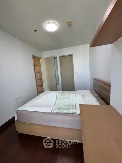 Cozy bedroom with modern design and wooden flooring in a stylish apartment.
