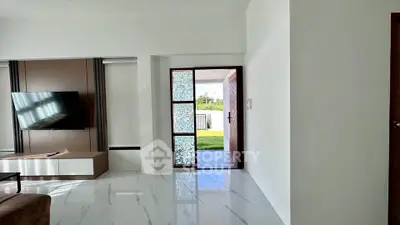 Modern living room with sleek TV setup and stylish entrance to garden.