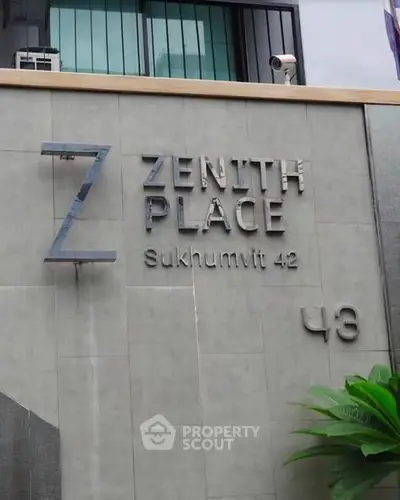 Modern exterior of Zenith Place Sukhumvit 42 with sleek signage and lush greenery.