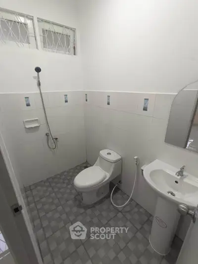 Compact bathroom with modern fixtures and tiled flooring