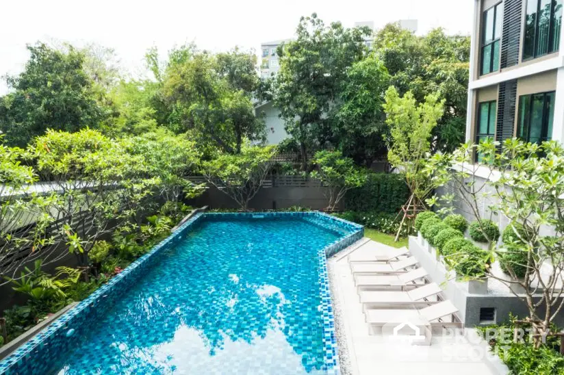 Luxurious outdoor pool surrounded by lush greenery and modern architecture