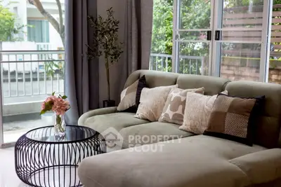 Chic living room with plush sofa, stylish cushions, and modern coffee table near large windows.
