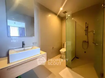 Modern bathroom with glass shower and sleek vanity in luxury apartment