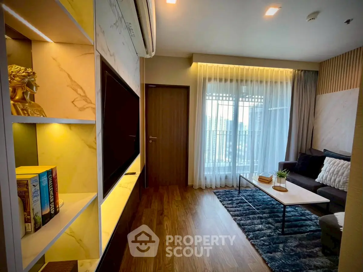 Modern living room with stylish decor and large window offering natural light.