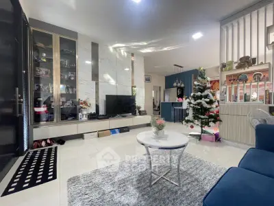 Modern living room with Christmas decor, sleek furniture, and stylish shelving.