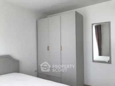 Minimalist bedroom with sleek wardrobe and mirror, perfect for modern living.