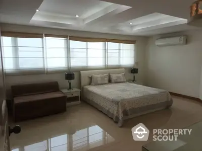 Spacious and elegantly appointed bedroom with polished floors, modern lighting, and large windows creating a serene ambiance perfect for relaxation.