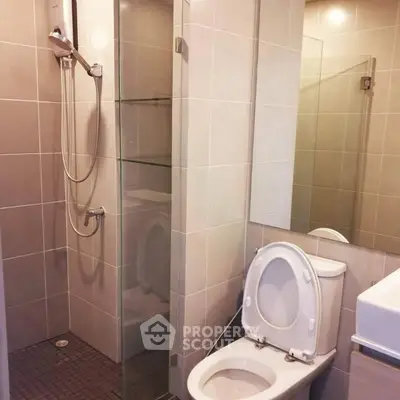 Modern bathroom with glass shower and sleek fixtures in contemporary apartment.