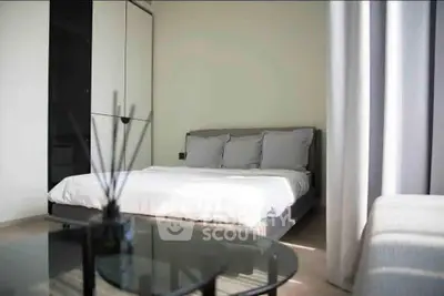 Modern bedroom with sleek design and natural light, featuring a comfortable bed and stylish decor.