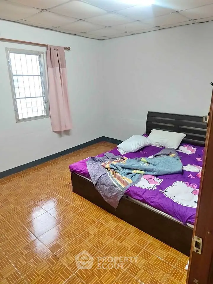 Cozy bedroom with tiled flooring and colorful bedding, perfect for a comfortable living space.