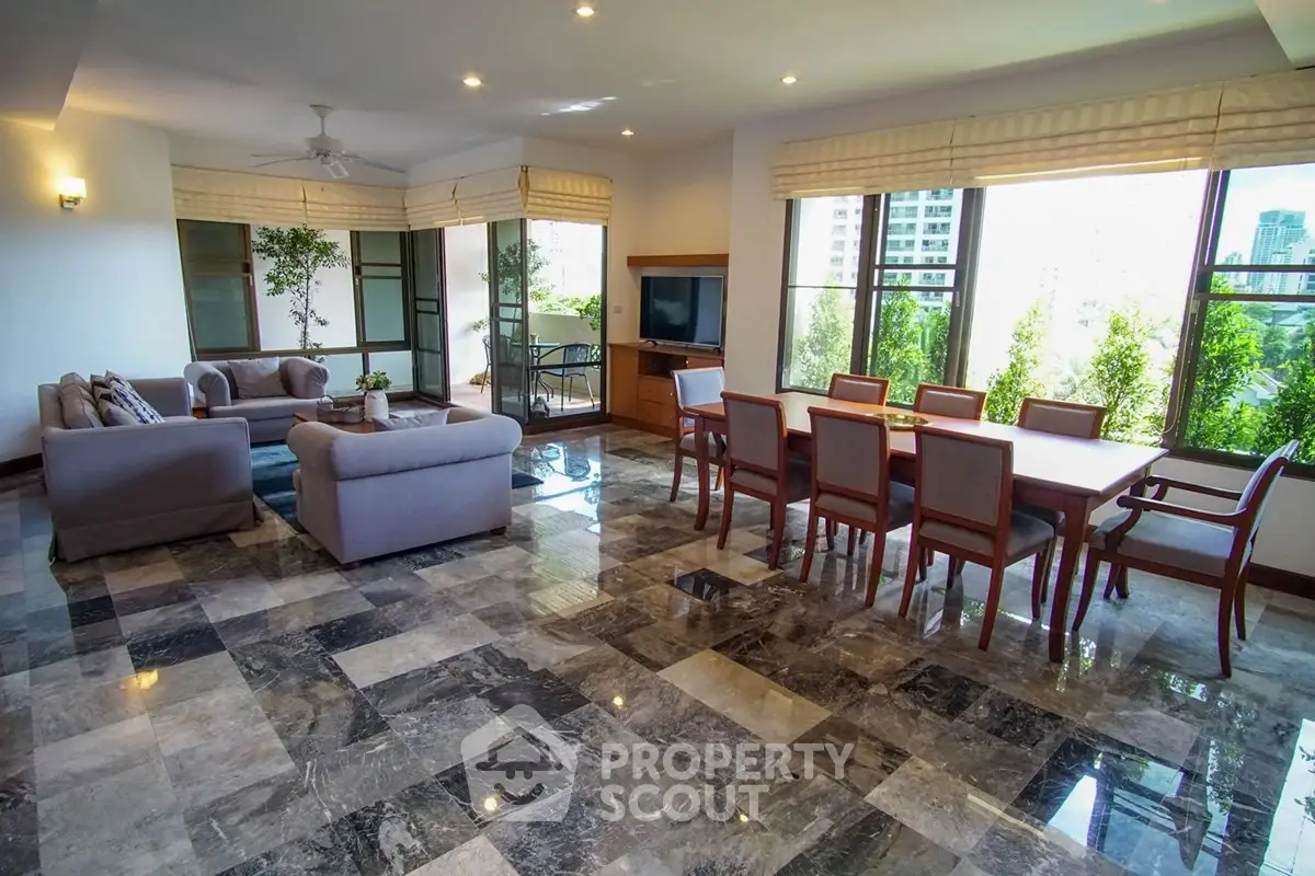 Spacious living room with elegant dining area and large windows offering city views.