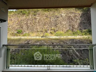 Scenic balcony view overlooking rocky hillside and lush greenery