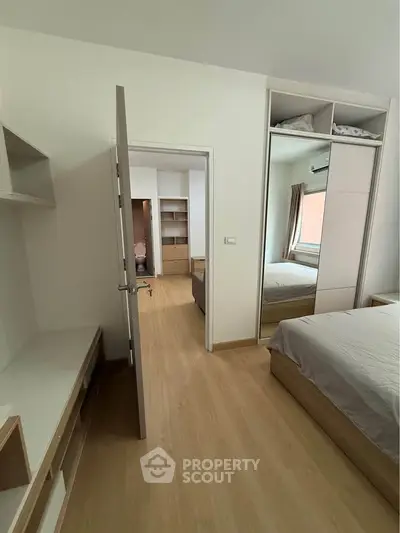 Spacious bedroom with modern design and ample storage in a stylish apartment.