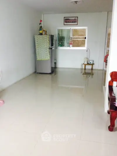Spacious minimalist living area with tiled flooring and natural light