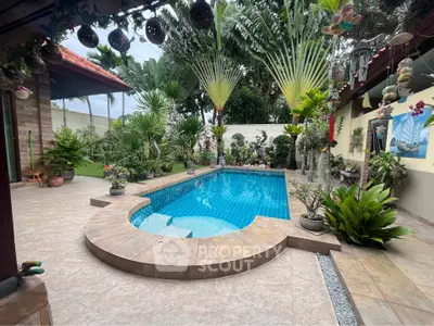 Stunning tropical backyard with a sparkling pool surrounded by lush greenery and elegant landscaping.
