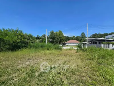 Spacious residential land plot with lush greenery and clear blue sky, ideal for building your dream home.