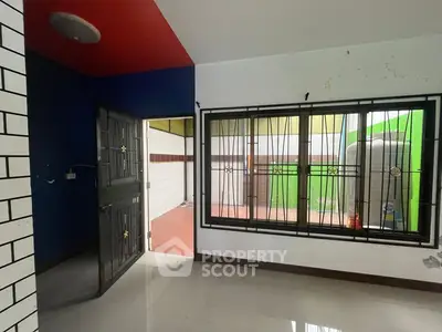 Spacious room with large window and modern tile flooring