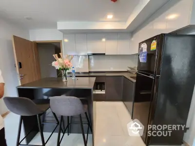 Modern kitchen with sleek cabinets and island seating in contemporary apartment