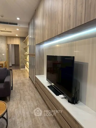 Modern living room with sleek wooden paneling and large flat-screen TV