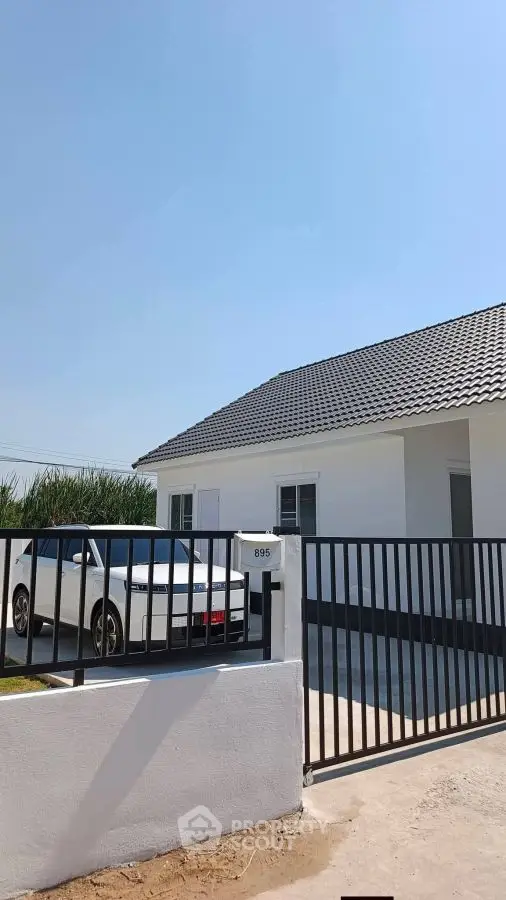 Charming modern house with sleek black gate and driveway, perfect for family living.