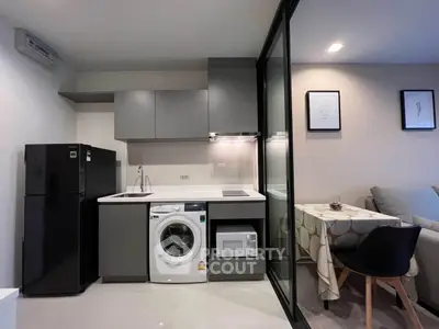 Modern compact kitchen with washing machine and microwave in stylish apartment