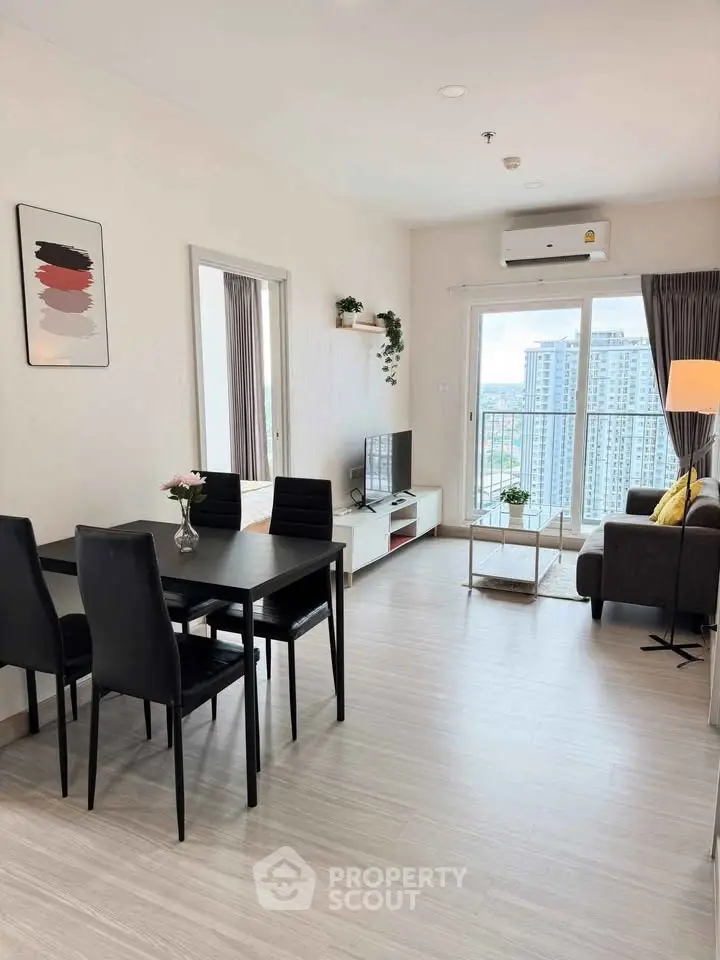 Modern living room with dining area and city view, featuring sleek furniture and natural light.