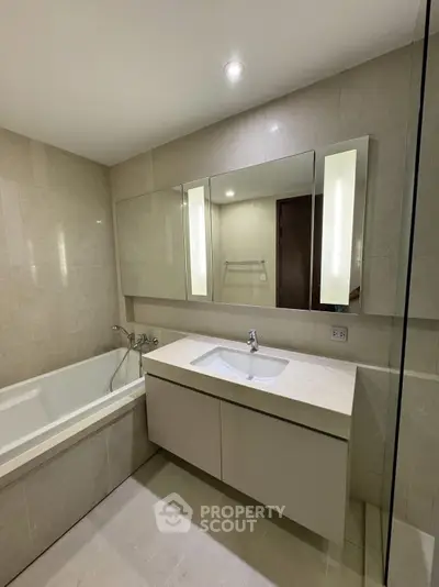 Modern bathroom with sleek vanity and bathtub in luxury apartment