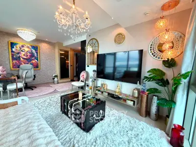 Luxurious living room with chic decor, chandelier, and large TV in modern apartment.