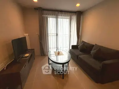 Cozy living room with modern furniture and natural light from large window.